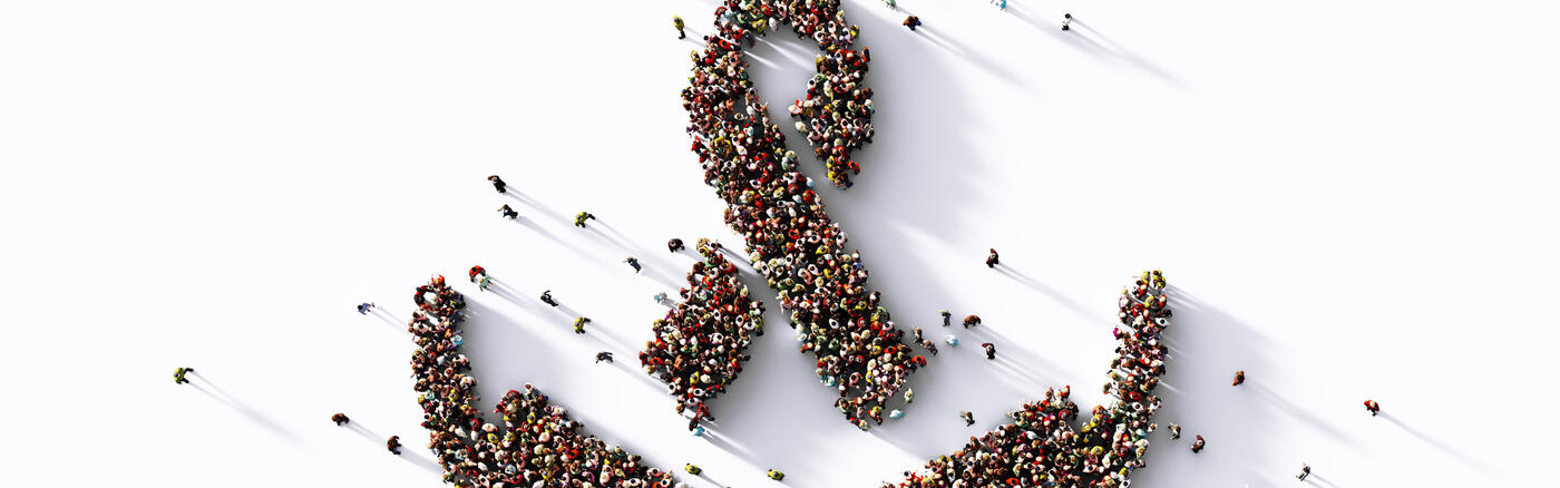 Human crowd forming an awareness ribbon symbol above human hands on white background.